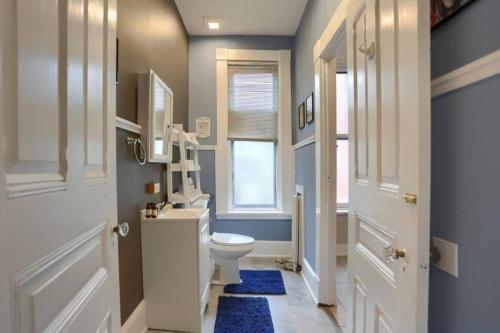 a bathroom with a white toilet and a window at Charming Downtown Retreat Steps from Capitol Bldg in Harrisburg