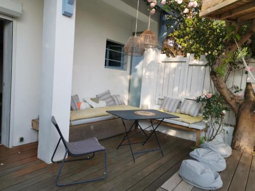 a patio with a table and chairs and a couch at Maison du bonheur in Lanton