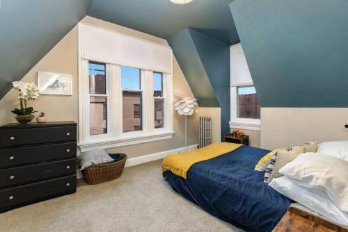 Dormitorio azul con cama y ventana en Stylish Private 2 Bed Apt en Harrisburg