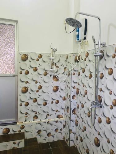 une salle d'eau avec un mur de tasses dans l'établissement thambara gueust house, à Habarana