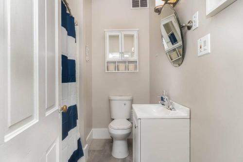 a bathroom with a white toilet and a mirror at Stylish Private 2 Bed Apt in Harrisburg