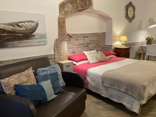 a bedroom with a bed and a couch at Tiny House in the center in Torri del Benaco