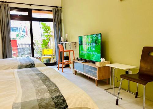 a bedroom with a bed and a flat screen tv at 心適都蘭Comfy Inn, Dulan in Donghe