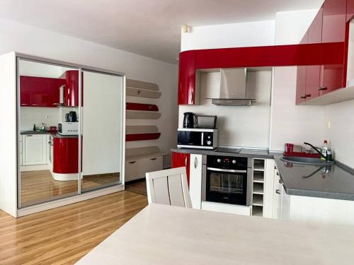 cocina con armarios rojos y blancos en una habitación en Cozy Rila Park Apartments en Borovets