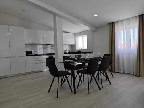 a dining room with a black table and chairs at Alojamento King´s Village in Albufeira
