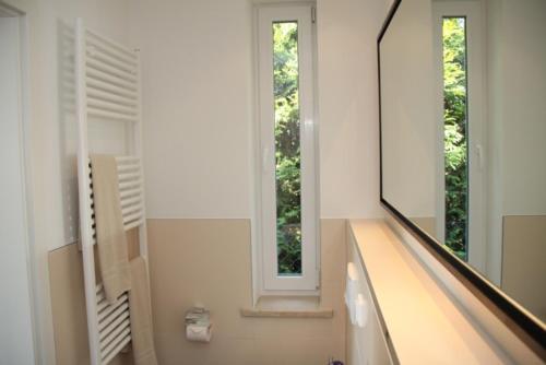 uma casa de banho com um lavatório, um espelho e uma janela em Ostseeparadies Kühlungsborn em Körchow