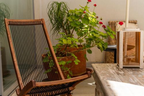 a wooden chair next to a table with a potted plant at BmyGuest - Meco Mar-Me-Quer House in Alfarim