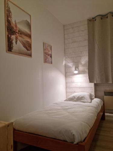 a bed in a bedroom with a picture on the wall at Hôtel Eden Lake in Égletons