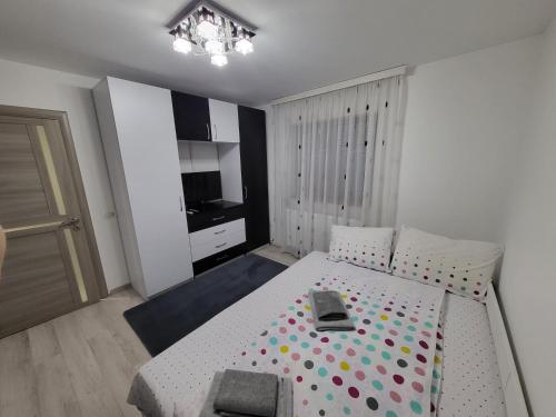 a bedroom with a white bed with polka dots on it at Casa Laura&Florin in Constanţa