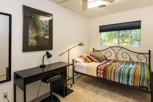 a bedroom with a bed and a desk and a window at Kapila Gardens Family Retreat w/ private pool in Cottonwood
