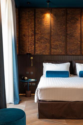 a bedroom with a large bed with blue and white pillows at Palazzo Velabro, a Member of Design Hotels in Rome