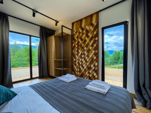 - une chambre avec un lit bleu et de grandes fenêtres dans l'établissement Carpathians View, à Krivopolʼye