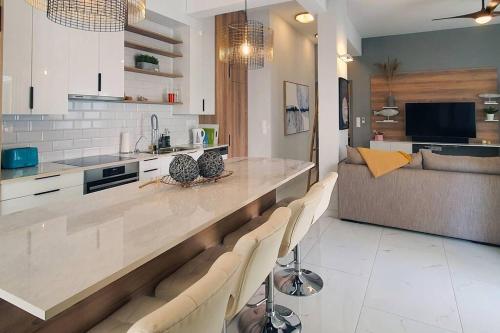 eine Küche und ein Wohnzimmer mit einer Theke und einer Couch in der Unterkunft Hidden gem on the Piraeus Coast in Piräus