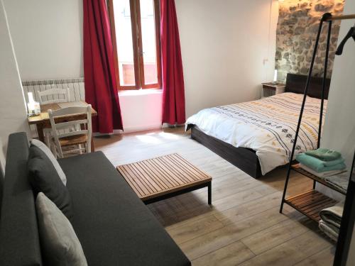 a living room with a bed and a couch at La petite étoile d'hôtes en Mercantour in Saint-Dalmas-le-Selvage