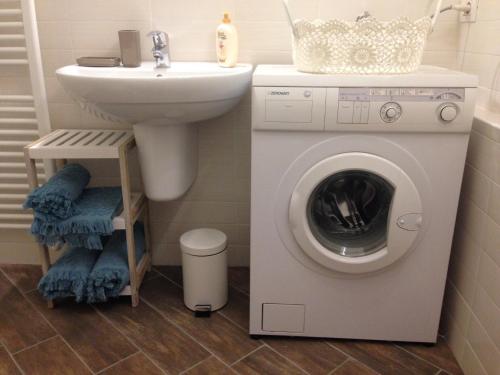 a bathroom with a washing machine and a sink at Tiny House in the center in Torri del Benaco