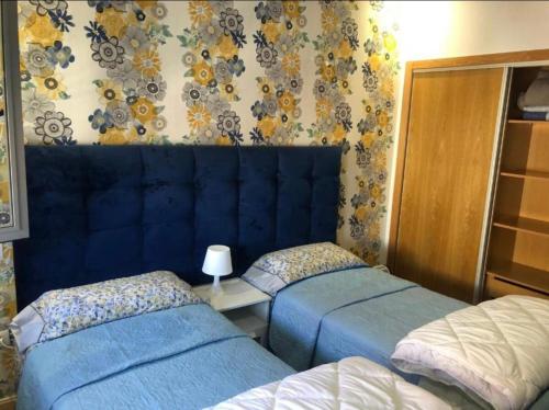 duas camas num quarto com capas azuis em CalmA em Fez