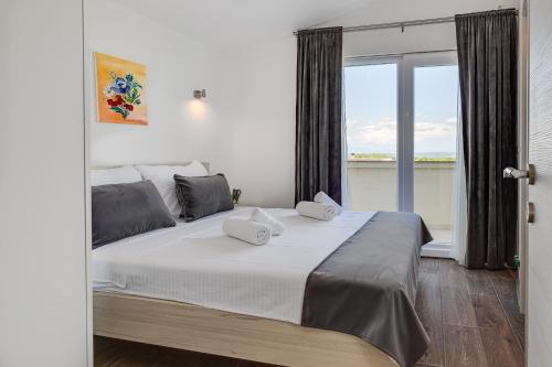 a bedroom with a large bed with a large window at Apartman David s bazenom i jakuzijem in Podušje