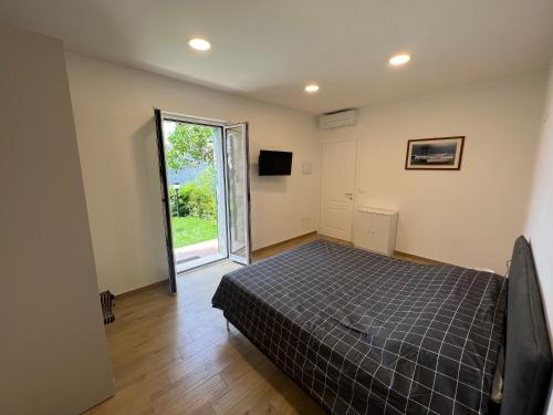 um quarto com uma cama e uma porta de vidro deslizante em BikeandClimb B&B em Finale Ligure