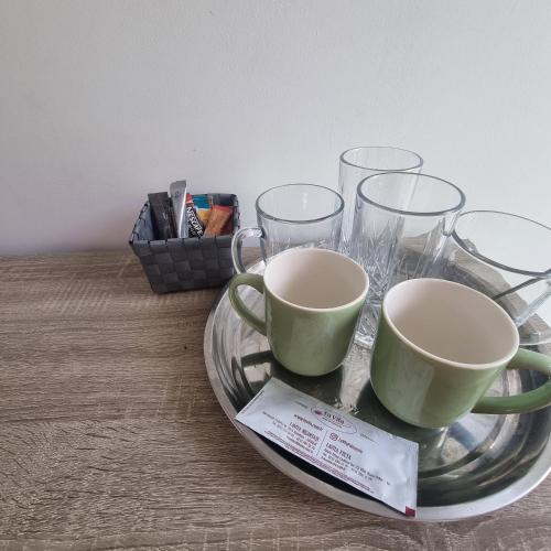 a tray with two cups and glasses on a table at Andreea's place in Braşov