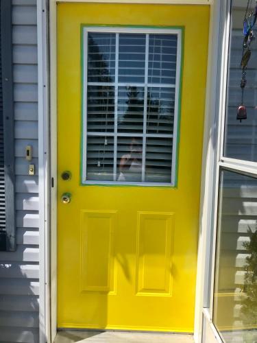a yellow door with a window on a house at Ingonish Loft in Ingonish