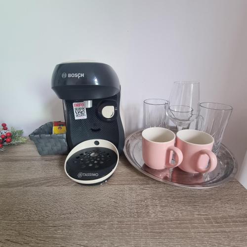 a coffee maker and two cups on a table at Andreea's place in Braşov