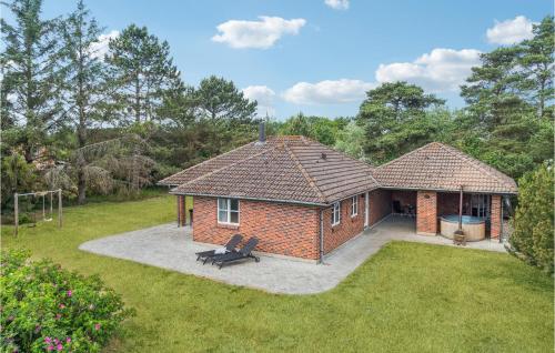 a brick house with a bench in a yard at Holiday Home Rodby Ii in Rødby