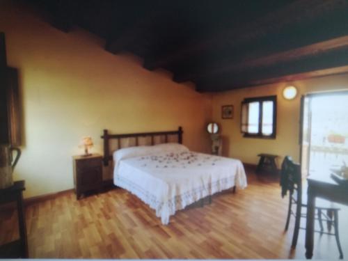 a bedroom with a bed and a wooden floor at Albergo Diffuso IL MIGLIO in Miglierina