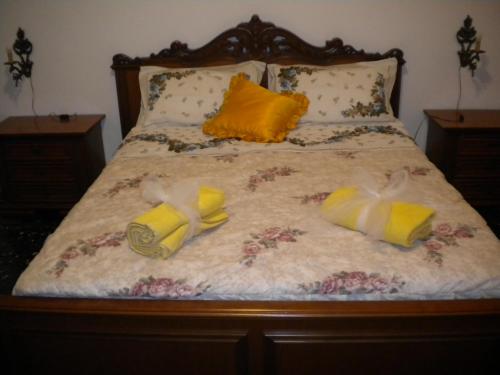Una cama con dos pares de zapatos. en Casa Fantasy Alloggio Turistico, en Tuscania