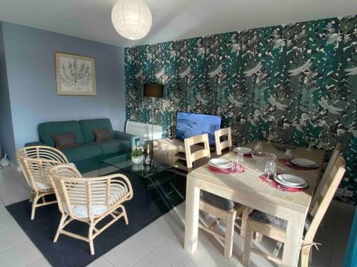 un salon avec une table et un canapé dans l'établissement La Libellule by Conciergerie Audrey, à Trouville-sur-Mer