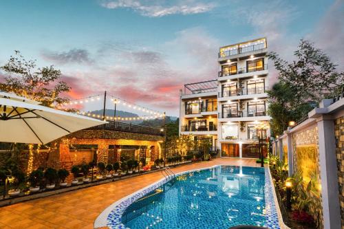 a hotel with a swimming pool in front of a building at Family House Nội Bài Airport Hotel & Villa in Ninh Môn