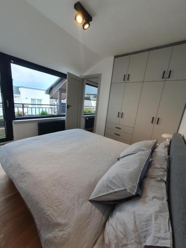 ein Schlafzimmer mit einem großen Bett und einem großen Fenster in der Unterkunft Modern top floor loft with balcony in Budapest