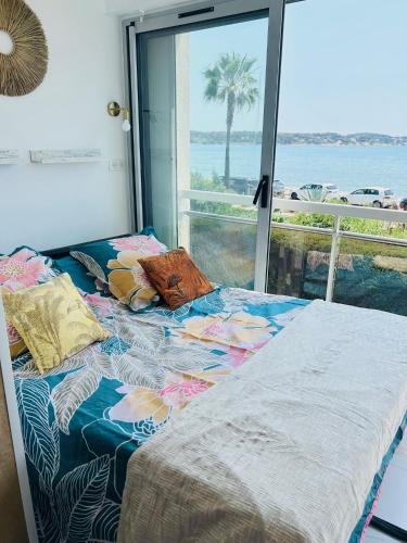 Ce lit se trouve dans un dortoir offrant une vue sur l'océan. dans l'établissement VUE MER ET A 20m DE LA PLAGE AVEC PARKING MARINDORE BANDOL, à Bandol