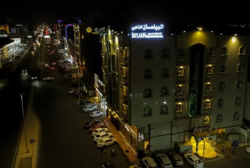 une ville la nuit avec des voitures garées dans un parking dans l'établissement البيلسان الذهبي 1, à Djeddah