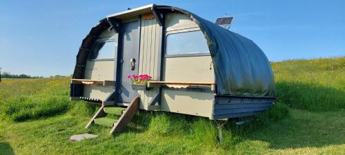 a camping trailer sitting in a field of grass at Little Middop Farm Camping Pods in Gisburn
