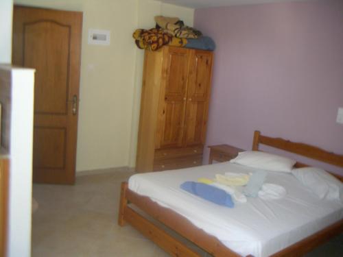 a bedroom with a bed and a wooden cabinet at Studios by Climbing House in Panormos Kalymnos