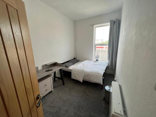a small bedroom with a bed and a window at Room in new flat in Walsall