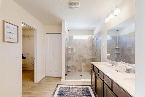 uma casa de banho com um chuveiro, um lavatório e um espelho. em Serenity by the Sea em Saint Augustine