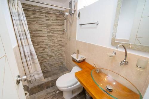 y baño con lavabo y aseo. en Acogedor apartamento cerca al mar. en Lima