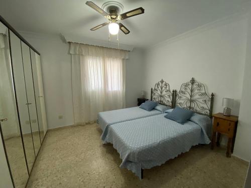 Schlafzimmer mit einem Bett und einem Deckenventilator in der Unterkunft ESPACIO Y LUZ en Isla Cristina Capacidad hasta 8 HUESPEDES in Isla Cristina