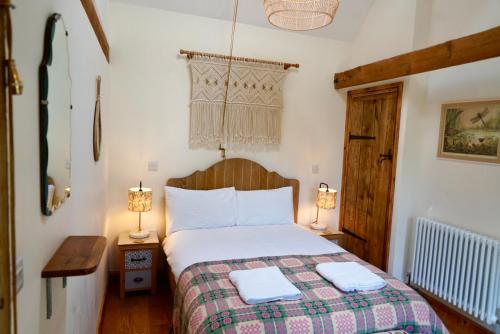 ein Schlafzimmer mit einem Bett und zwei Lampen an Tischen in der Unterkunft Nest Holiday Hideaway Wren Cottage Stunning Area! in Church Stretton