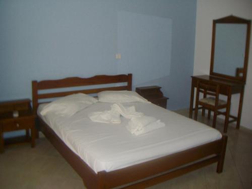 a bedroom with a bed with white sheets and towels at Studios by Climbing House in Panormos Kalymnos