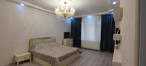 a bedroom with a bed and a chandelier at Caspian Seaside Villa in Sumqayyt
