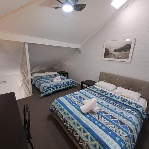 1 Schlafzimmer mit 2 Betten und einem Deckenventilator in der Unterkunft Resort Loft & Spa Villa #8 in Mandurah