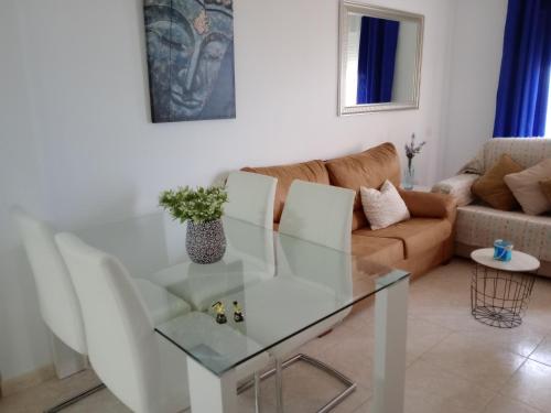 ein Wohnzimmer mit einem Glastisch und einem Sofa in der Unterkunft Mediterráneo lux in Aguadulce