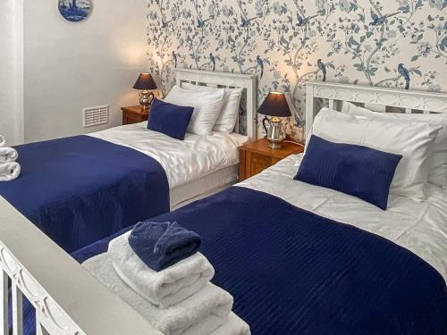 2 camas en un dormitorio con azul y blanco en Llys Deulyn en Trefriw