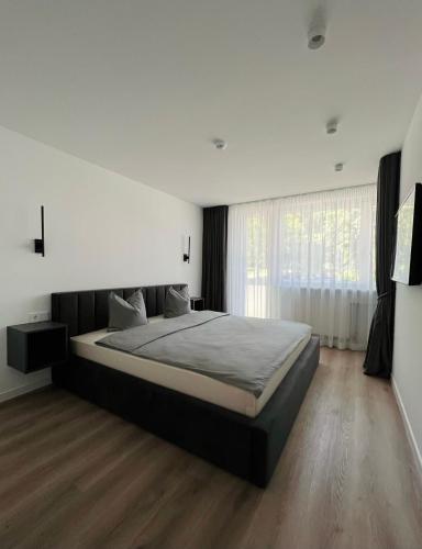 Un dormitorio con una cama grande y una ventana en EZì Apartment, en Šiauliai