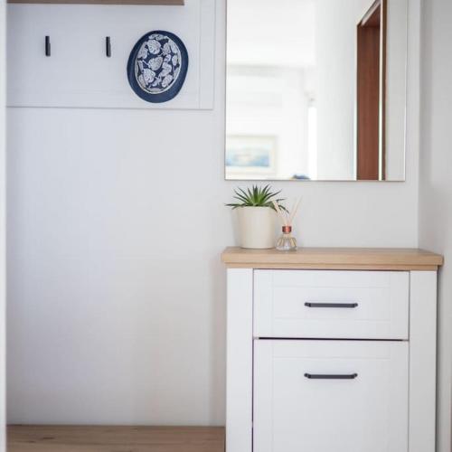 a bathroom with a white cabinet and a mirror at Apartman Maris in Split