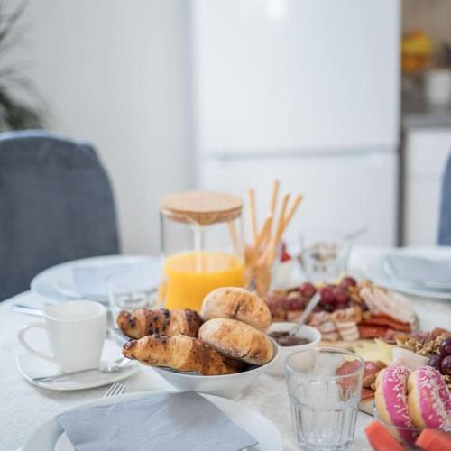 a table with a plate of pastries and orange juice at Apartman Maris in Split