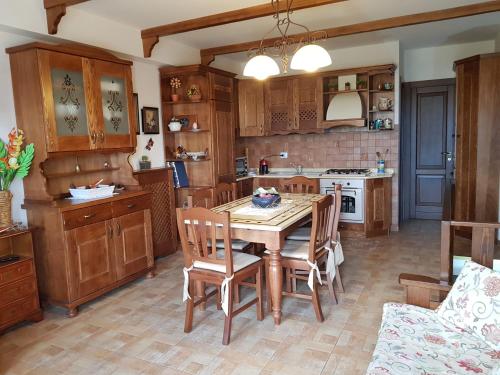 a kitchen with wooden cabinets and a table and chairs at Villetta La Pigna in Castel di Sangro