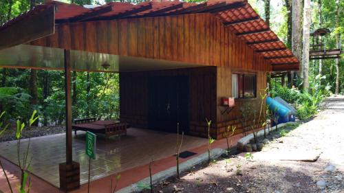 a wooden house with a bench on a patio at Recreo Verde Hot Springs & Spa in Marsella